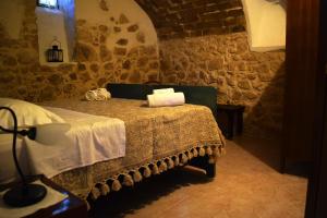 1 dormitorio con 1 cama en una pared de piedra en Il Ciavattone Bed and Bike, en Sulmona