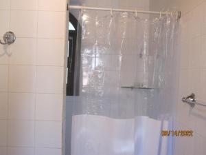 a shower with a plastic shower curtain in a bathroom at Janela dos Meus Sonhos in Penedo