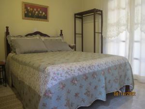 a bedroom with a bed with a floral bedspread at Janela dos Meus Sonhos in Penedo