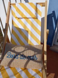 Un cojín en una silla con un cartel. en Beach House - Casa de Férias MONTE CLÉRIGO, en Aljezur