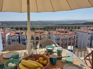 a table with a basket of fruit on a balcony at Beach House - Casa de Férias MONTE CLÉRIGO in Aljezur