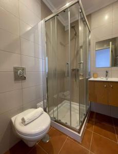 a bathroom with a shower and a toilet and a sink at Beach House - Casa de Férias MONTE CLÉRIGO in Aljezur