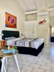 a bedroom with a large bed and a table at Seru Coral Resort studio 16 in Willemstad