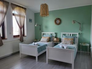2 camas en una habitación con paredes verdes en Sobe Pilajevo 2, 183 Ulica Stjepana Radića, Gola, en Gola