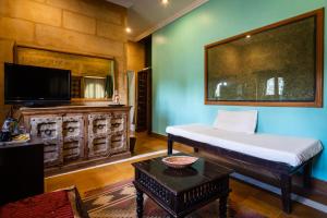 uma sala de estar com uma cama e uma televisão em Hotel Fifu em Jaisalmer