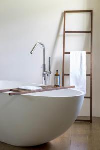 a white bath tub in a bathroom with a towel rack at Le Manoir de La Fieffe in Cherbourg en Cotentin