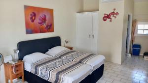 1 dormitorio con 1 cama y una pintura en la pared en Seru Coral Resort studio 16 en Willemstad