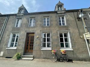 budynek z rowerem zaparkowanym przed nim w obiekcie Maison spacieuse authentique proche St Malo Rennes, bienvenue à la Casa Cozumel w mieście Pleugueneuc
