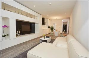 uma sala de estar com um sofá branco e uma televisão em Amazing luxurious studio Space Available em Acra