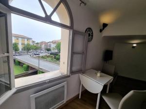 Pokój z oknem, stołem i umywalką w obiekcie Studio "Le Vauban" Perpignan Centre Ville w Perpignanie