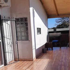 uma vista exterior de uma casa com uma porta e um alpendre em Casa con piscina en Gobernador Roca em Gobernador Roca