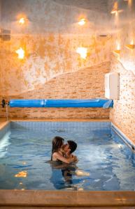 un hombre y una mujer en una piscina en Villa Avoti, en Sigulda