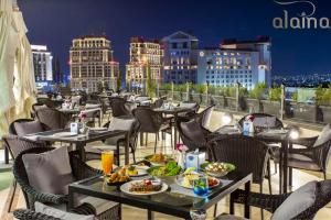 a restaurant on the roof of a building with food on tables at Retaj Hotel in Amman