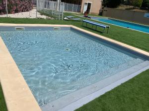 een zwembad met een bank in het gras bij Résidence de vacances soleiluna in Rocbaron