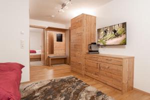 1 dormitorio con 1 cama y TV en la pared en Appart Klotz, en Längenfeld