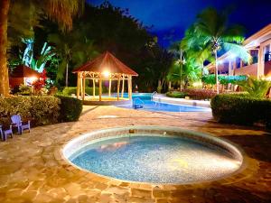 - une piscine avec un kiosque dans la cour la nuit dans l'établissement Lovely 2-BDroom Condo in Laguna Eco Village Resort, à Quepos