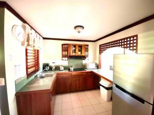 cocina con fregadero y nevera en Lovely 2-BDroom Condo in Laguna Eco Village Resort en Quepos