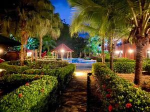 - un jardin de nuit avec un kiosque et des palmiers dans l'établissement Lovely 2-BDroom Condo in Laguna Eco Village Resort, à Quepos