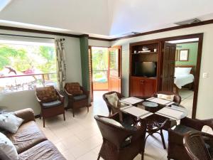 un soggiorno con tavolo, sedie e televisione di Lovely 2-BDroom Condo in Laguna Eco Village Resort a Quepos