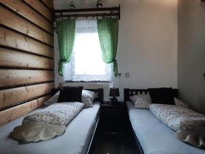 two twin beds in a room with a window at Chalupa pri vodopade in Lúčky