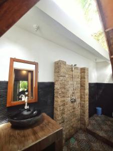ein Bad mit einem Waschbecken und einem Spiegel in der Unterkunft Follow The Rabbit Bungalow in Gili Air
