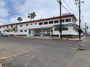 un bâtiment blanc avec un toit rouge dans une rue dans l'établissement Hotel Presidente, à Ensenada