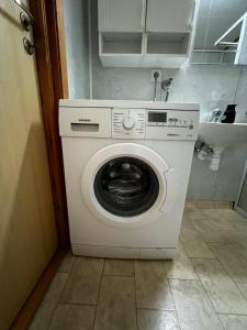 uma máquina de lavar e secar roupa num pequeno quarto em Privat rom i leilighet em Sogndal