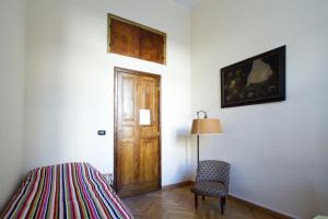 トリノにあるB&B Meucciのベッド1台、ドア、椅子が備わる客室です。