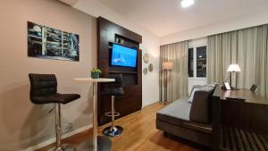 a bedroom with a bed and a desk and a tv at STD - Anora Spaces - Stadium Alphaville in Barueri