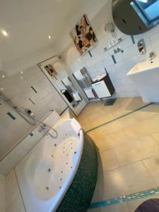 ein Badezimmer mit einer Badewanne und einem Waschbecken in der Unterkunft Hotel Karthäuser Hof in Flörsheim