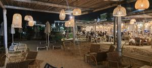 un restaurant avec des chaises, des tables et des lustres dans l'établissement Private Apartment in Saint Elena, à Saints Constantine et Helena