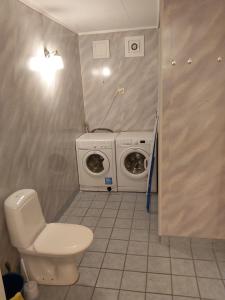 a bathroom with a toilet and a washing machine at Ålesund Apartment with free parking in Ålesund