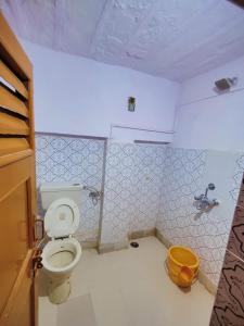 a bathroom with a toilet and a yellow bucket at Sagar Guest House in Jaisalmer