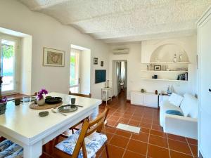 a kitchen and living room with a table and chairs at Aria di Collina - Isola d'Elba in Porto Azzurro