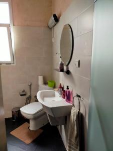 uma casa de banho com um lavatório, um WC e um espelho. em Casa Tligui em Arzila