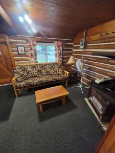 a room with a couch and a table and a stove at Two Rivers Motel and Cabins 