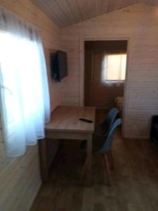 a small room with a wooden table and a window at Domek u Ani in Giżycko