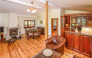 - un salon avec un fauteuil en cuir et une cheminée dans l'établissement Holiday Home Nowe Warpno With Fireplace I, à Nowe Warpno