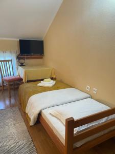 a small bedroom with two beds and a chair at Bed and Breakfast Albatros in Perušić