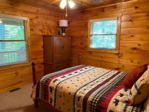 a bedroom with a bed in a log cabin at Hibernation Hideaway in Blairsville