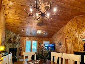 a dining room with a wooden ceiling with a chandelier at Hibernation Hideaway in Blairsville