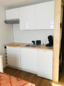 a kitchen with white cabinets and a sink at la daurade du frioul , île du Frioul, marseille in Marseille