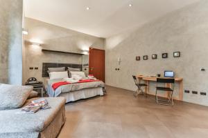 San Babila Suite في ميلانو: غرفة نوم مع سرير وطاولة مع لاب توب