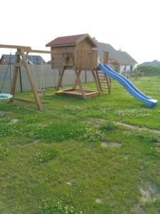 a playground with a blue slide in the grass at Domek u Ani in Giżycko