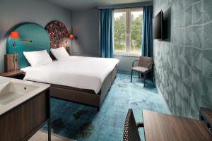 a hotel room with a bed and a sink at Hotel Babylon Heerhugowaard - Alkmaar in Heerhugowaard