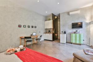 San Babila Suite في ميلانو: غرفة معيشة مع طاولة ومطبخ