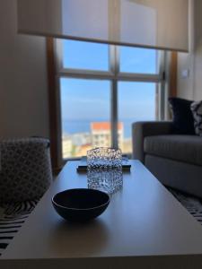 Apartamento con vistas al mar في مالبيسا: وعاء أسود على طاولة في غرفة المعيشة