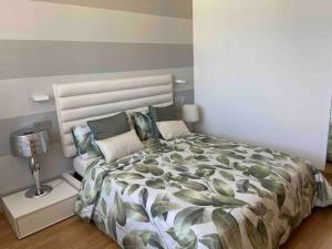 Apartamento con vistas al mar في مالبيسا: غرفة نوم بسرير كبير ومصباح