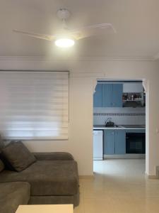 a living room with a couch and a kitchen at Adosado tranquilo con piscina y vistas al mar in Puerto Marino