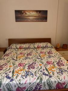 una cama con un edredón colorido en un dormitorio en La Rosa del lago, en Bracciano 47 fotos más
